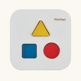 Overhead view of the PlanToys shape and sort it out bin wooden shape sorter toy. Square box with lid with three shaped holes in the lid. Yellow triangle, red cylinder and blue cube blocks.
