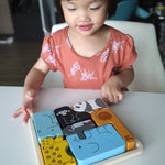 Girl looking at the Plan Toys eco-friendly wooden animal figures jigsaw puzzle game on a white table