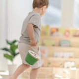 Child carrying the PlanToys geo sorting bucket wooden shape sorting toy. 