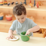 Child taking the wooden blocks out of the PlanToys geo sorting bucket wooden shape sorting toy. 