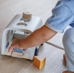 A close up of a toddler playing with the PlanToys Sorting Bus Baby Toy. 