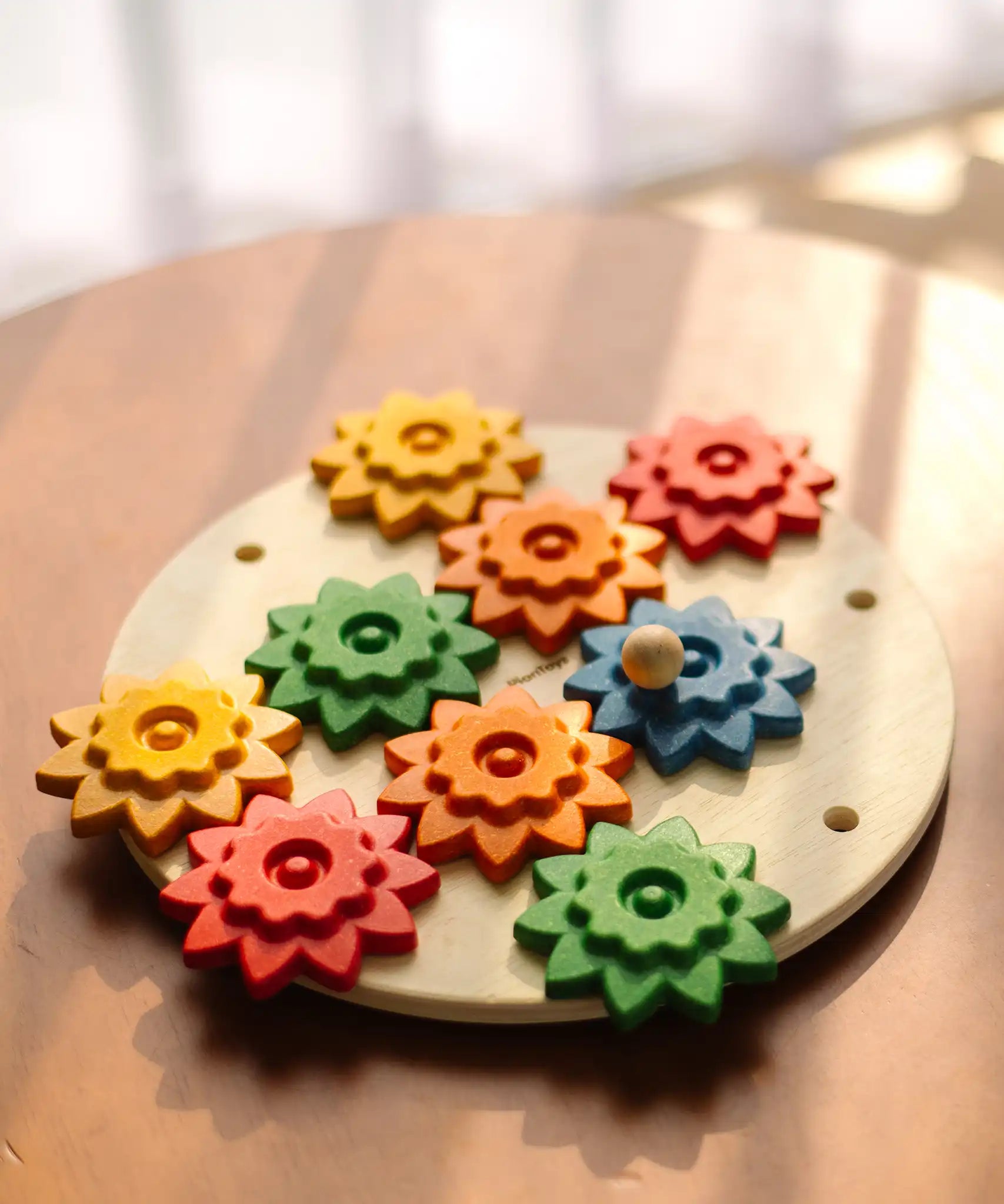 PlanToys spinning gear wooden toy playset placed on a circular table.