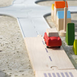 Plan Toys Standard Road System pictured set up on concrete connected to the rubber road set with a red vehicle on the road