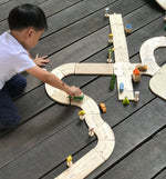 Child playing with the Plan Toys Standard Road System
