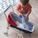 Child tucking in a teddy bear in a PlanToys stroller