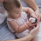 A baby playing with the PlanToys wobbly penguin toy. 