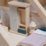 A close up of the wardrobe from the PlanToys Bedroom Dolls House Furniture set placed in a room in a wooden dolls house. 