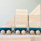PlanToys blue wooden hybrid train placed on natural wooden blocks. Three carriage train with magnetic connections. 