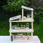 The living room, kitchen / diner and bathroom Plan Toys PlanSpace sets shown stacked on top of each other to create a 3 storey house. The levels can be arranged to the users preference offering a fully customised set up. 