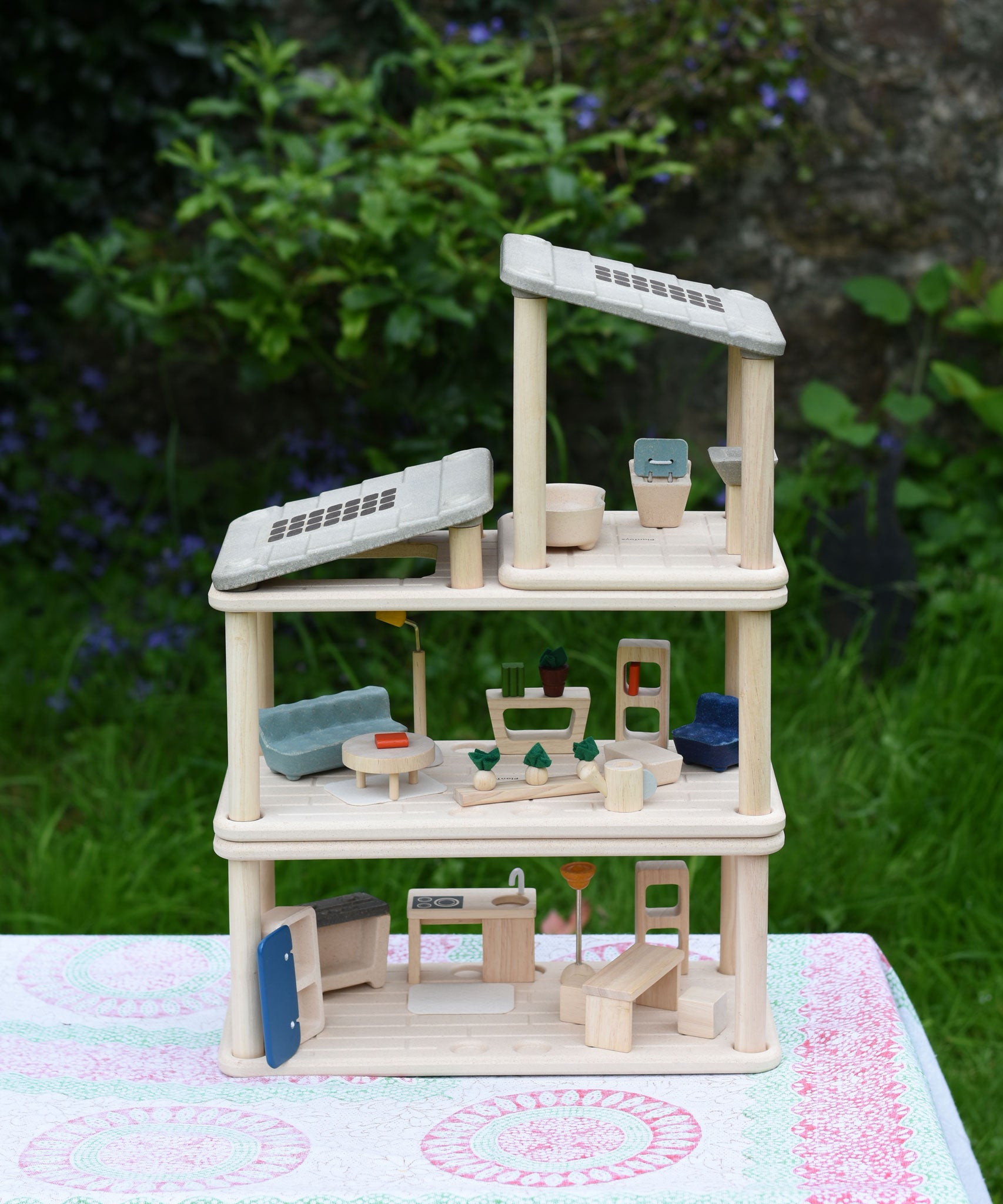 The living room, kitchen / diner and bathroom Plan Toys PlanSpace sets shown stacked on top of each other to create a 3 storey house. The levels can be arranged to the users preference offering a fully customised set up. 
