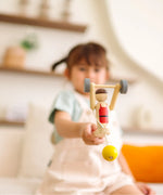 Child playing with the PlanToys Weightlifting Acrobat wooden toy.