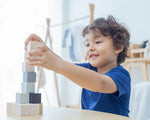 A child playing with the Plan Toys 15 Cubes.
