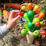 A close up the PlanToys Balancing Cactus being played with outdoors. 
