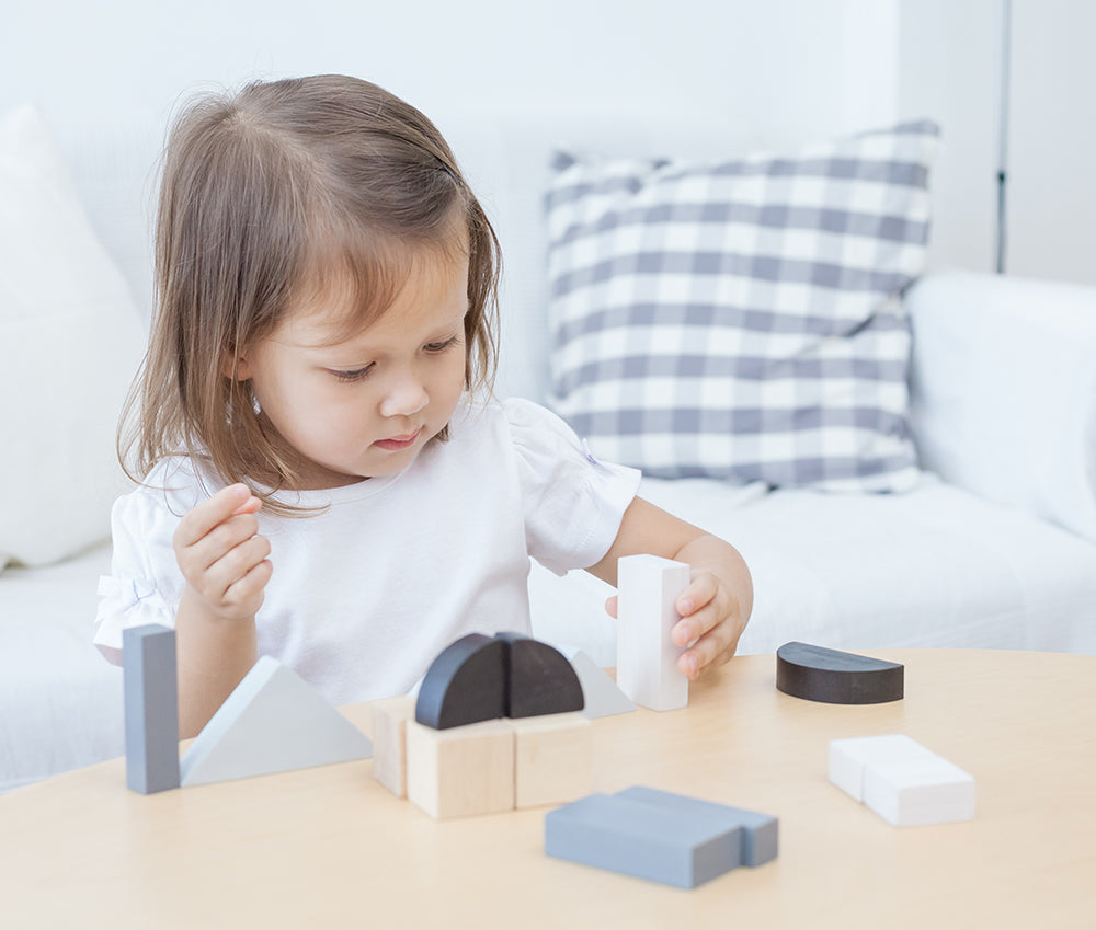 A child playing with the Plan Toys Fractions Blocks. 