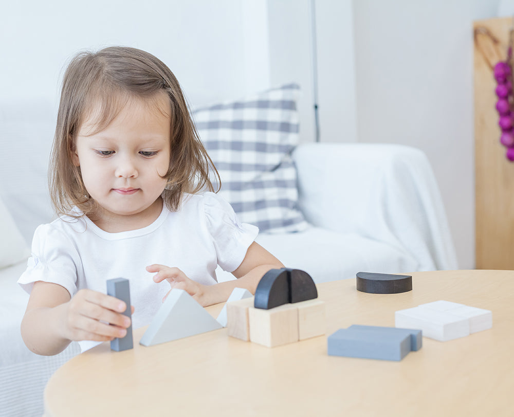 A child playing with the Plan Toys Fractions Blocks. 