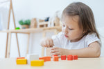 A child playing with the PlanToys Fractions Cubes. 
