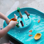 A close up of a child's hand playing with the PlanToys Water Play Set. 
