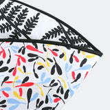 A baby laying down and looking at the black and white Fern side of the Etta Loves Reversible Organic Cotton Baby Play Mat - Plant Print 