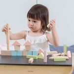 A child playing with the PlanToys Pastel Blocks set on a PlanToys desk. 