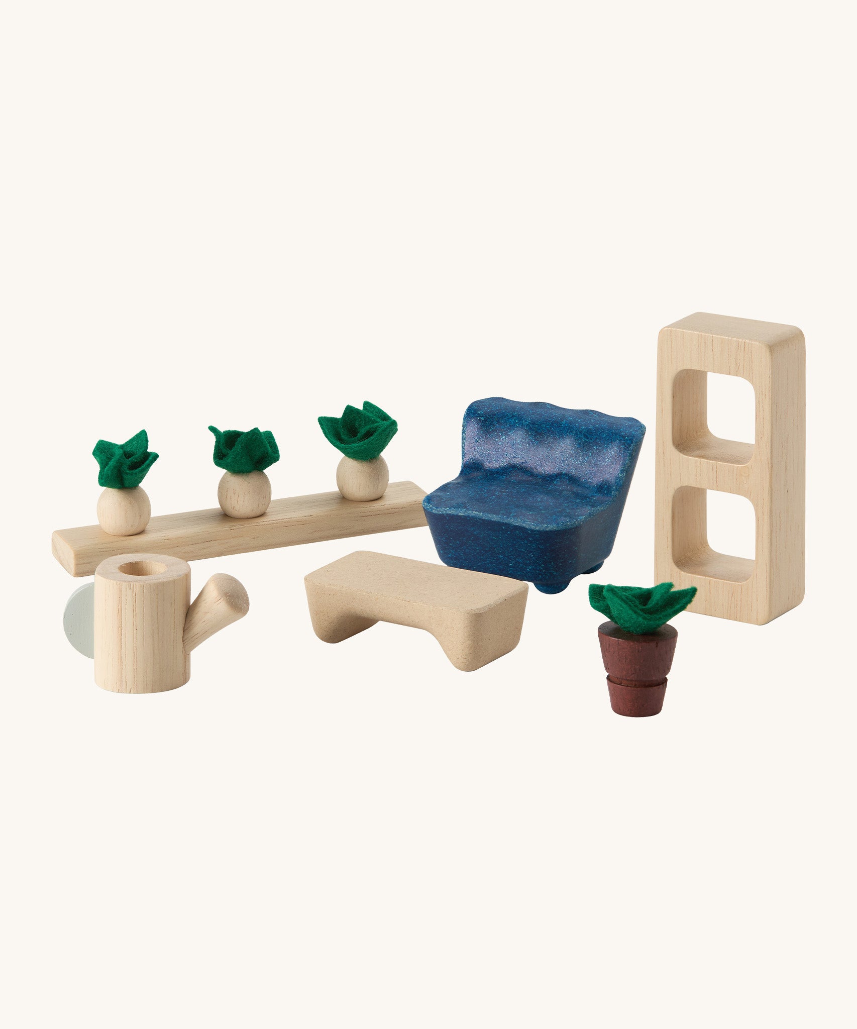 A close up view of the PlanToys wooden space living room accessories including a chair, footstool, bookshelf, plant, watering can and a veg patch.