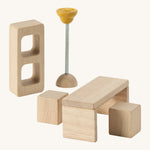 A close up view of the PlanToys wooden space kitchen room accessories including a bookshelf, table, lamp and chairs. Perfect for a dollhouse.