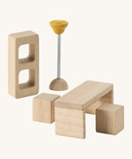 A close up view of the PlanToys wooden space kitchen room accessories including a bookshelf, table, lamp and chairs. Perfect for a dollhouse.