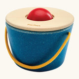 Educator sitting with a toddler learning object permanence with the ball drop toy