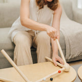 An adult assembling the PlanToys High Contrast Wooden Baby Play Gym. This wooden baby gym has high contrast coloured features and detailing. The gym comes with two wooden hanging toys, a planet and a rocket. PlanToys range of toys are made from sustainably sourced rubberwood, we're proud stockists of PlanToys here at Babipur. 