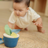 Baby crawling towards the PlanToys baby tissue box wooden sensory toy.