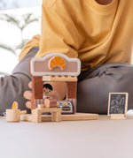 Child playing with the PlanToys bakery shop wooden toy playset.
