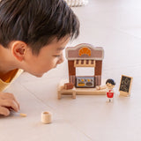 Child playing with the PlanToys bakery shop wooden toy playset.
