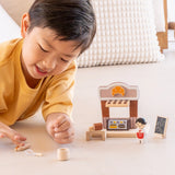 Child playing with the PlanToys bakery shop wooden toy playset.