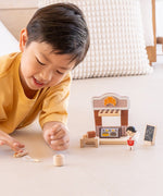 Child playing with the PlanToys bakery shop wooden toy playset.