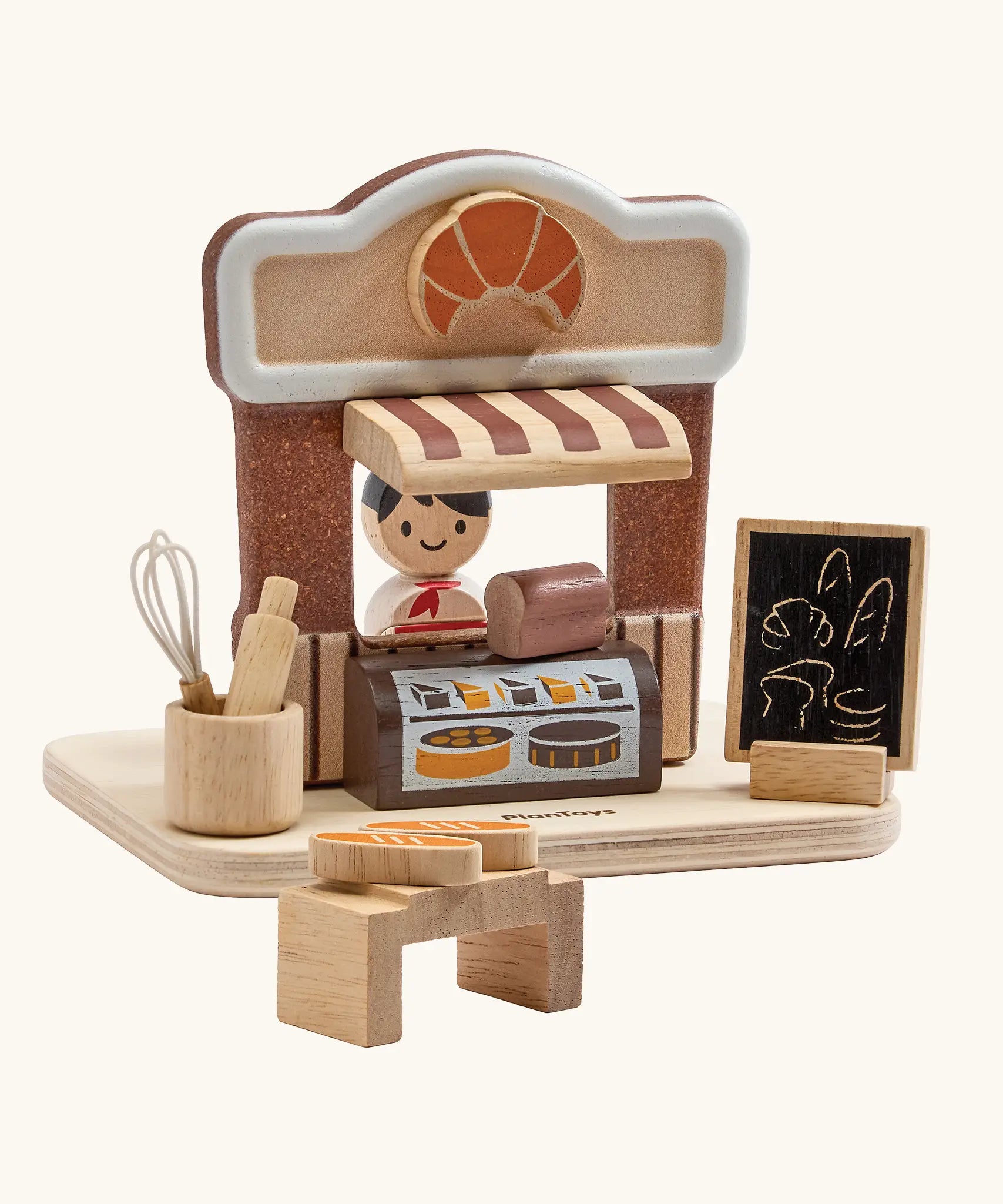 PlanToys bakery shop wooden toy playset. Shop with counter, toy bread, baking tools, advert board and worker figure.
