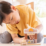 Child playing with the PlanToys bakery shop wooden toy playset.