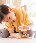 Child playing with the PlanToys bakery shop wooden toy playset.