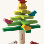 The PlanToys Balancing Tree on a plain background shown stacked up in a traditional tree style formation.

