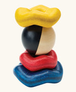 PlanToys wave ball stacker wooden stacking toy. Blue, yellow and red wavy rings with a black and white ball. 