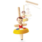 PlanToys wooden ballet spinning top. Showing the spinning top in action and the handle in the background.