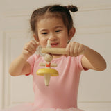Child threading the string on the handle ready to spin the PlanToys ballerina spinning top
