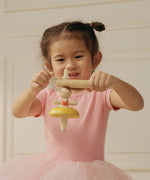 Child threading the string on the handle ready to spin the PlanToys ballerina spinning top