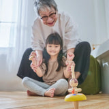 Child and grandmother playing with the PlanToys ballet spinning top on the floor 