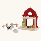 PlanToys barn house small world play set. Red wooden barn, mini veg patch, fences, cow, sheep, hen and farmer figure. 