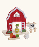 PlanToys barn house small world play set. Red wooden barn, mini veg patch, fences, cow, sheep, hen and farmer figure. 