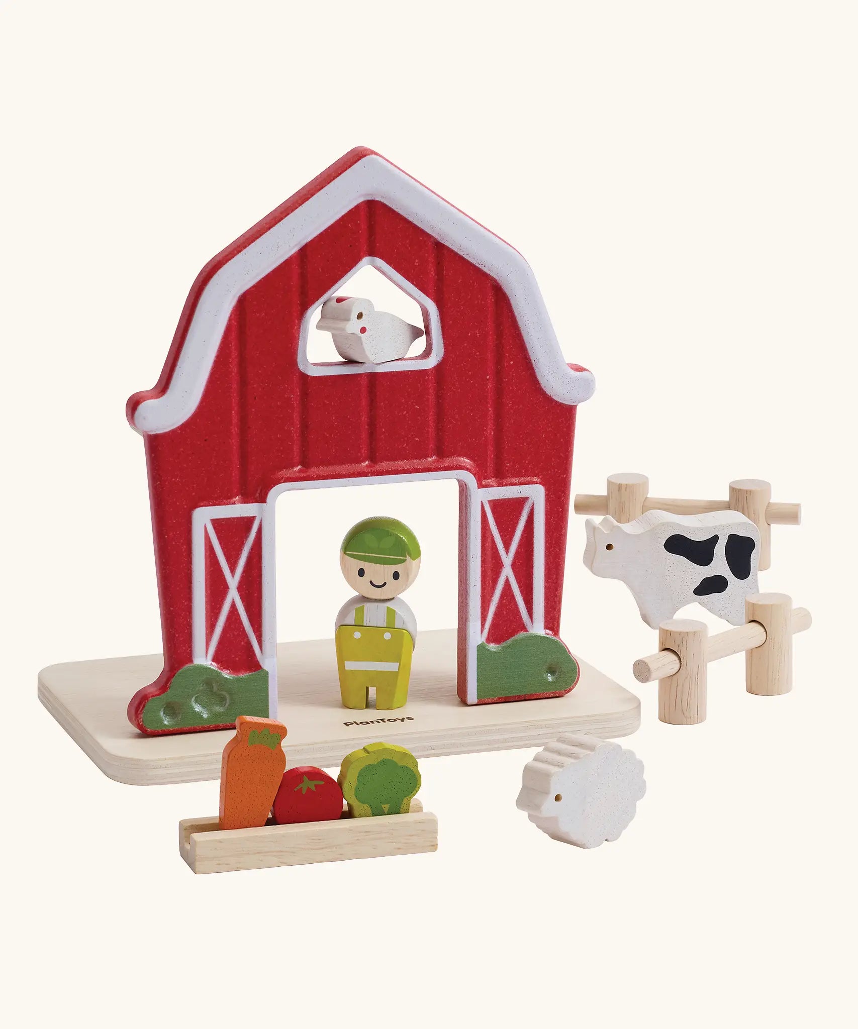 PlanToys barn house small world play set. Red wooden barn, mini veg patch, fences, cow, sheep, hen and farmer figure. 