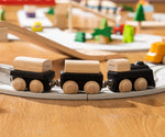 PlanToys black wooden classic toy train on a rubber railway track. 
