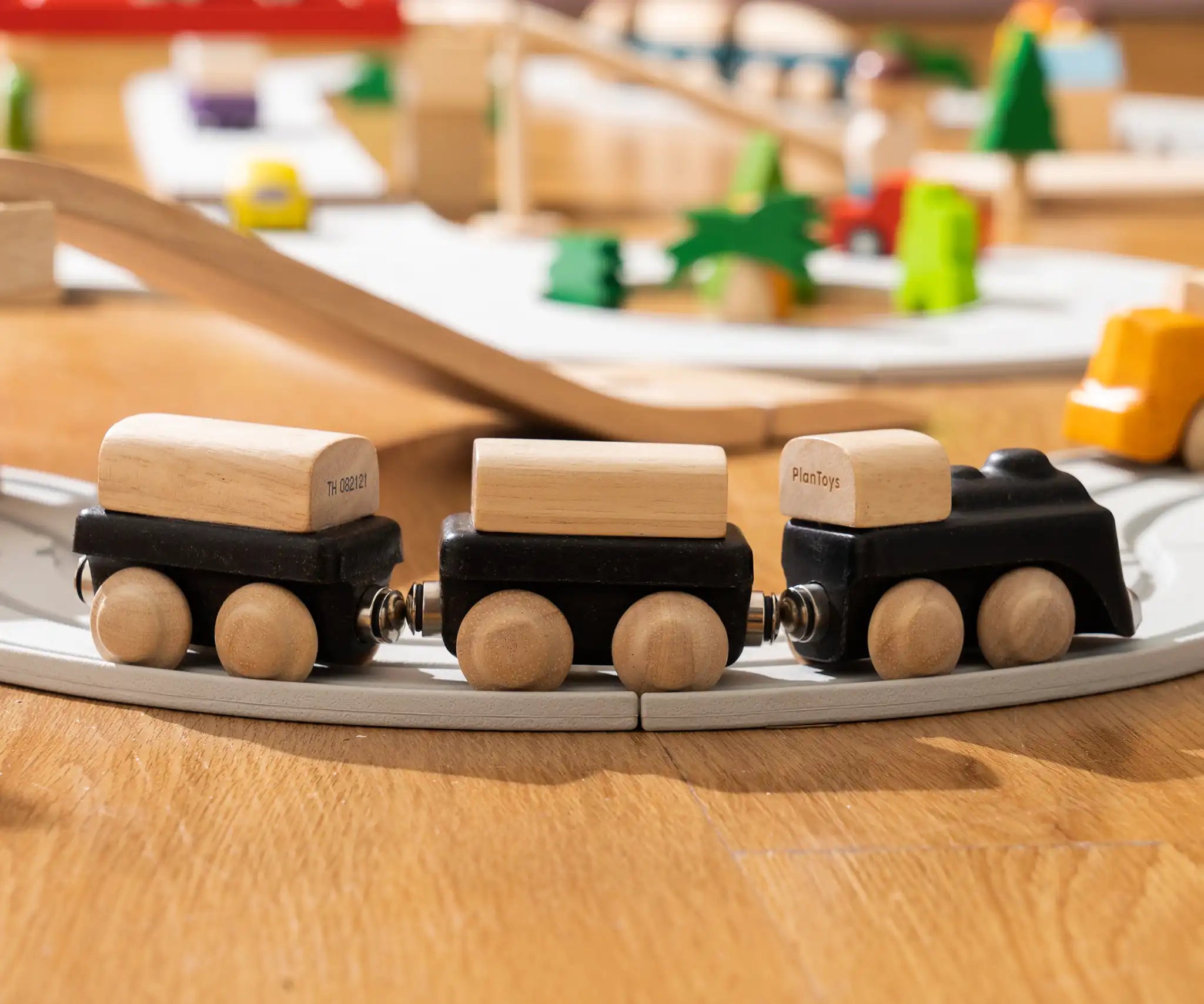 PlanToys black wooden classic toy train on a rubber railway track. 
