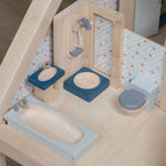The PlanToys Bathroom Dolls House Furniture set placed in a wooden dolls house. 