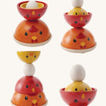 The PlanToys Chicken Nesting toy shown stacked in different ways  on a plain background. 