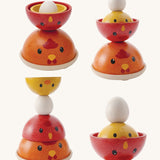 The PlanToys Chicken Nesting toy shown stacked in different ways  on a plain background. 